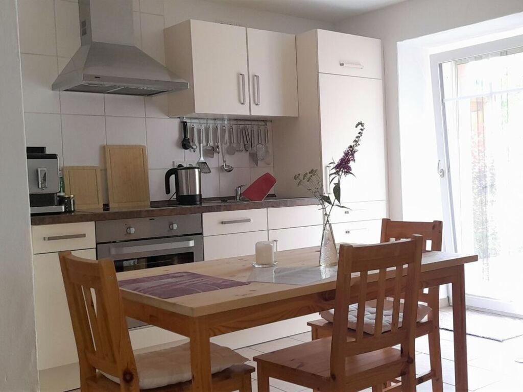 eine Küche mit einem Holztisch mit 2 Stühlen, einem Tisch und einem Tisch in der Unterkunft Charming apartment in Mandelbachtal in Wittersheim