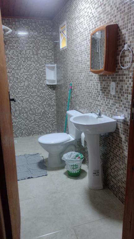 a bathroom with a toilet and a sink at Casa confortável! in Uruguaiana