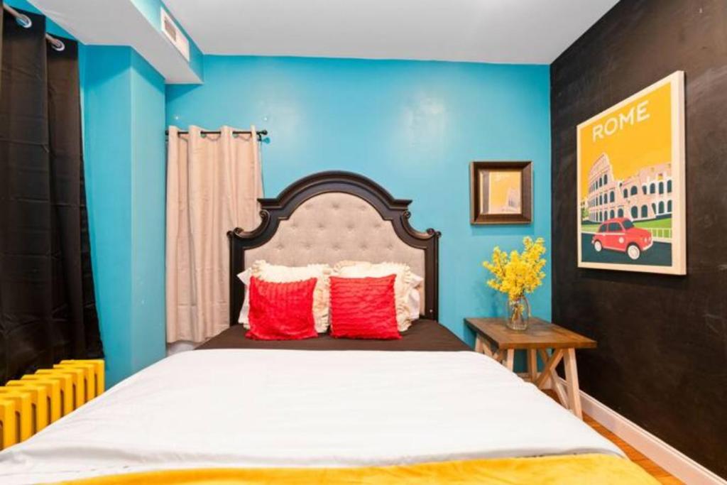 um quarto com uma cama com paredes azuis e almofadas vermelhas em Charming Little Italy Baltimore Gem em Baltimore