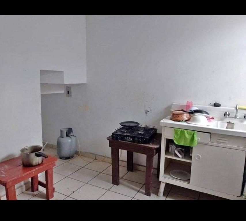 een keuken met een fornuis, een wastafel en een tafel bij Martyshouse in Poza Rica de Hidalgo