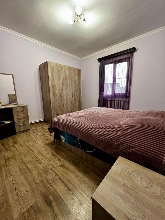 a bedroom with a bed and a dresser and a window at New , comfortable 3 bedroom house in Yerevan