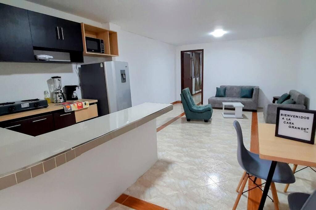 una cucina e un soggiorno con tavolo e sedie di Hermoso Apartamento en Ipiales a Ipiales