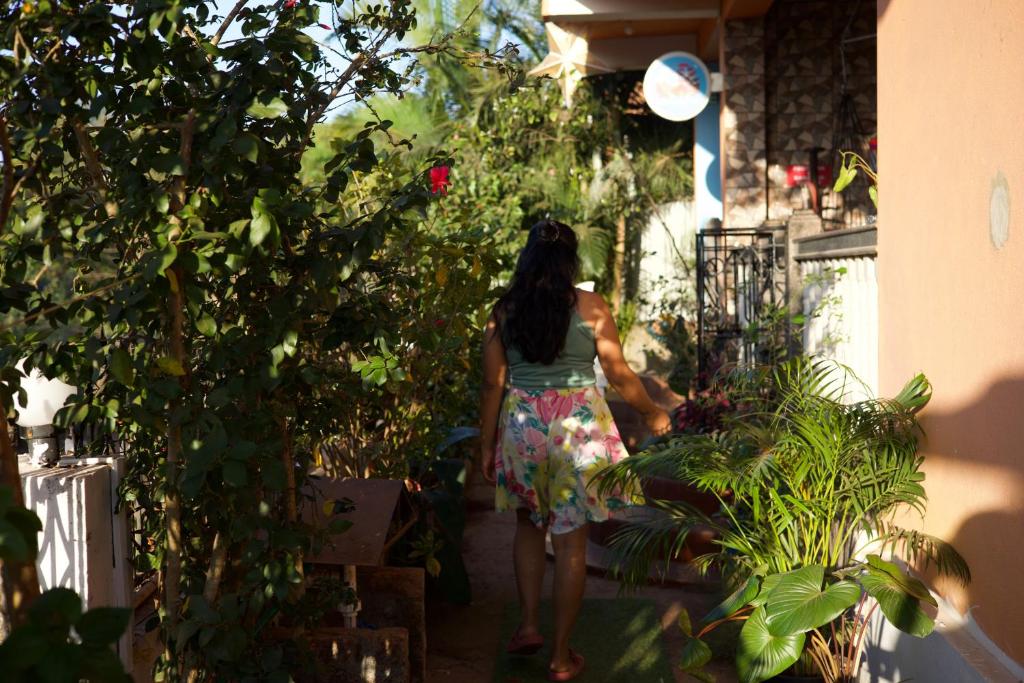 a woman walking through a garden with plants at Last Minute Trip Hostel Morjim in Morjim