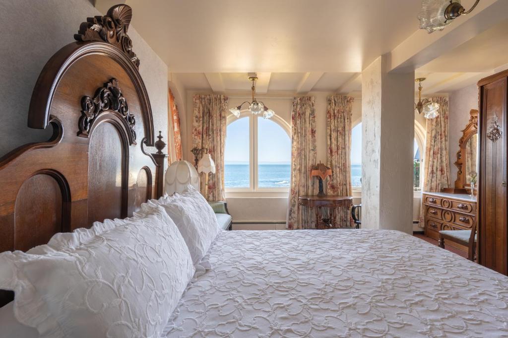 um quarto com uma cama grande e vista para o oceano em Martine Inn em Pacific Grove