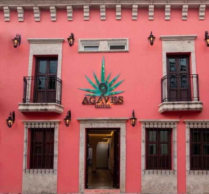un edificio rosso con un cartello sul lato di Nueve Agaves Hotel a Tequila