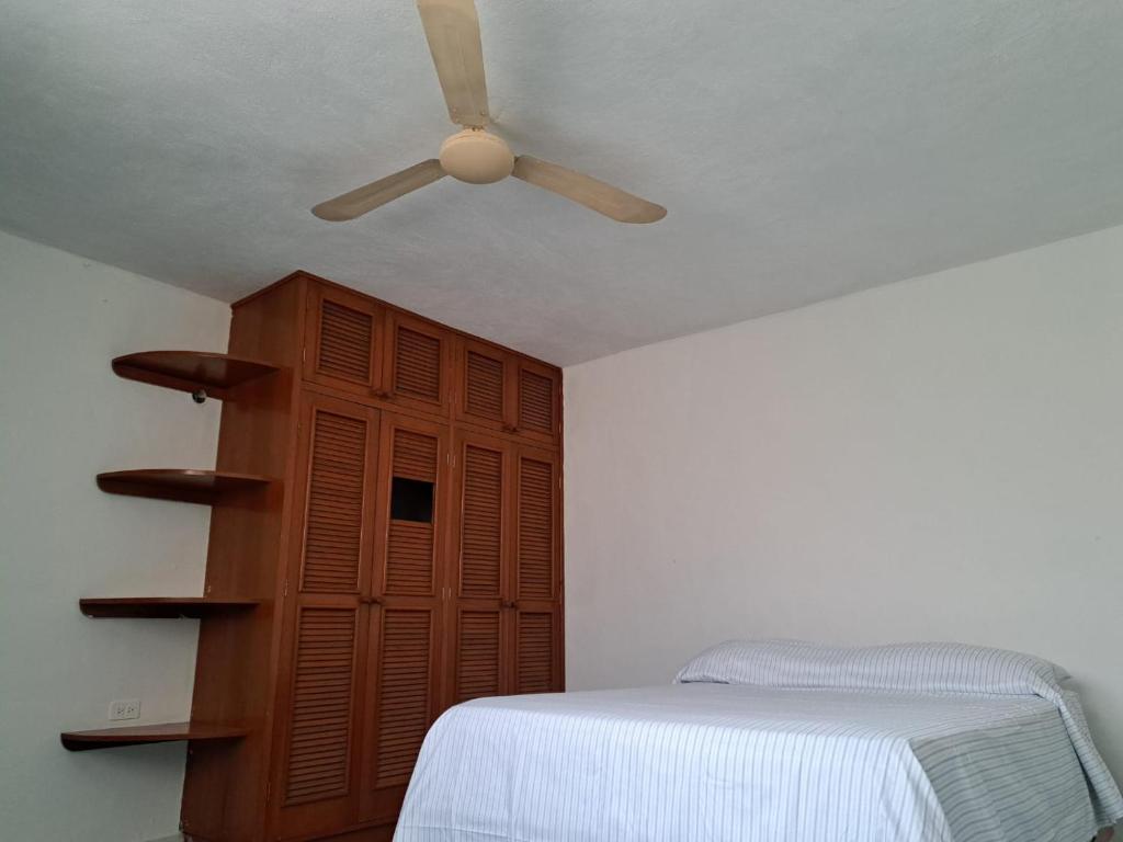 1 dormitorio con ventilador de techo y 1 cama en Aurora, en Cancún