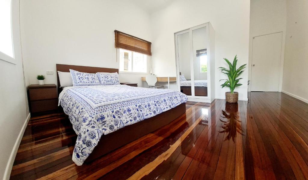 una camera con un letto con una coperta blu e bianca di Entire 2-Bedrm Unit in Maryborough CBD, Furnished a Maryborough