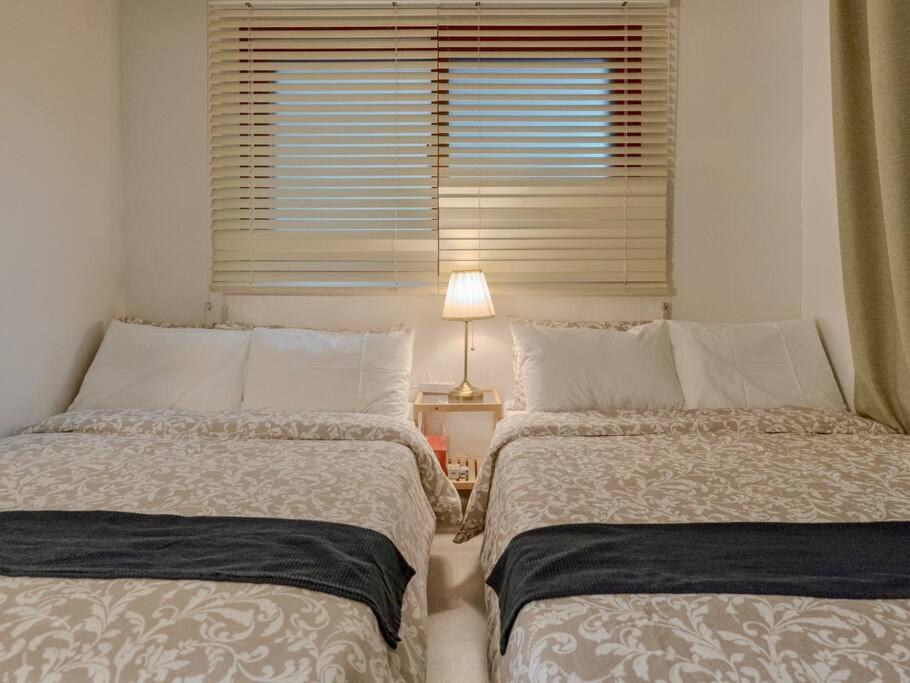首爾的住宿－Hongdae Cozy，卧室设有两张床、窗户和一盏灯