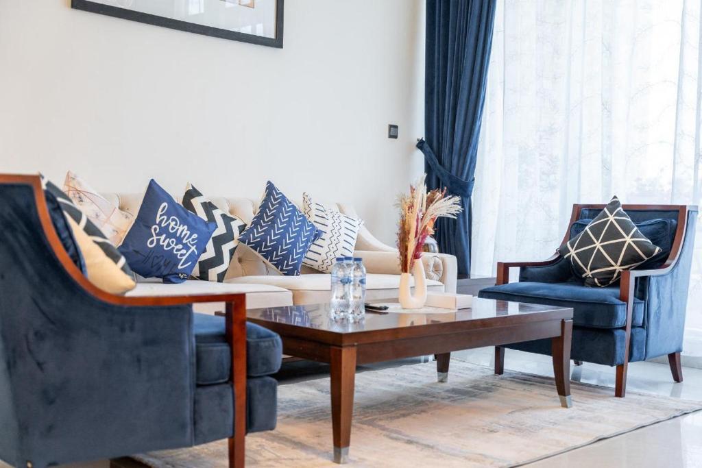 a living room with two chairs and a coffee table at Trinity Holiday Homes - Polo Residences Meydan in Dubai