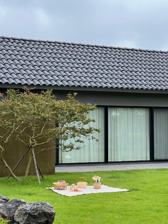 a house with a tree in the front yard at On Stay Jeju in Jeju