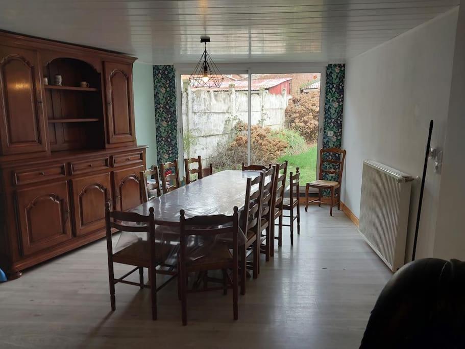 uma sala de jantar com mesa e cadeiras em une escapade a la campagne ? em Longueval