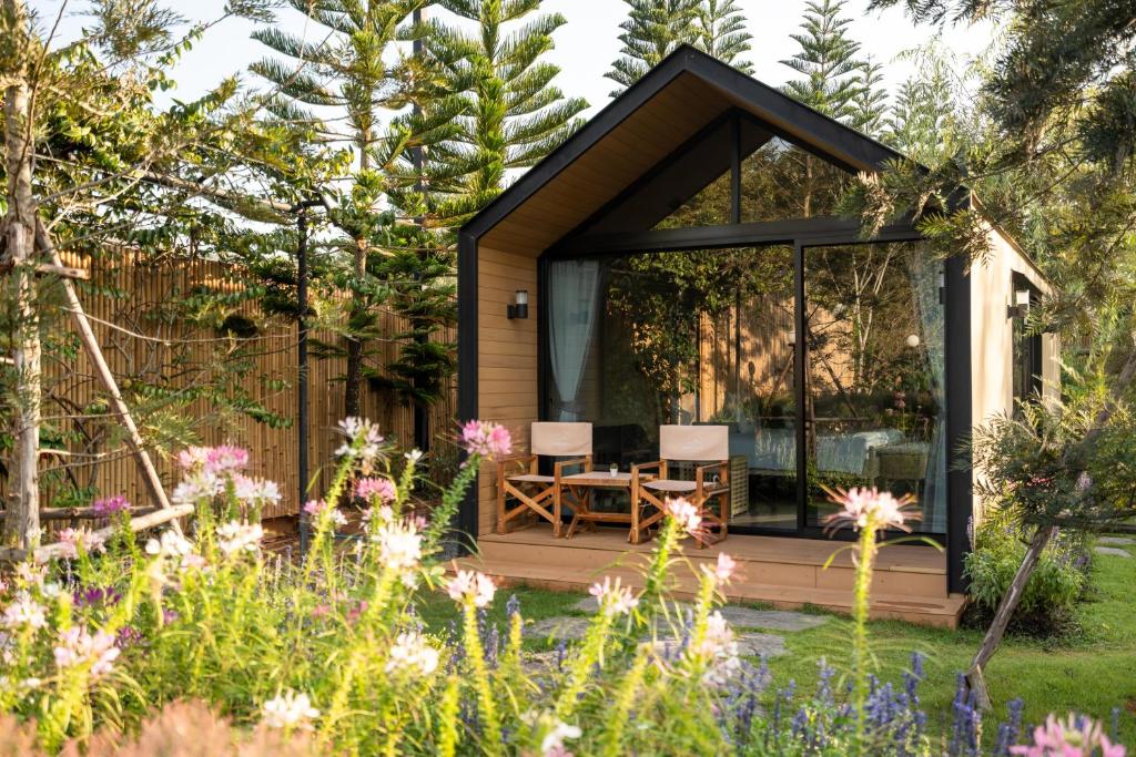 a tiny house in a garden with a table and chairs at Thara Dara Khaoyai in Ban Tha Maprang