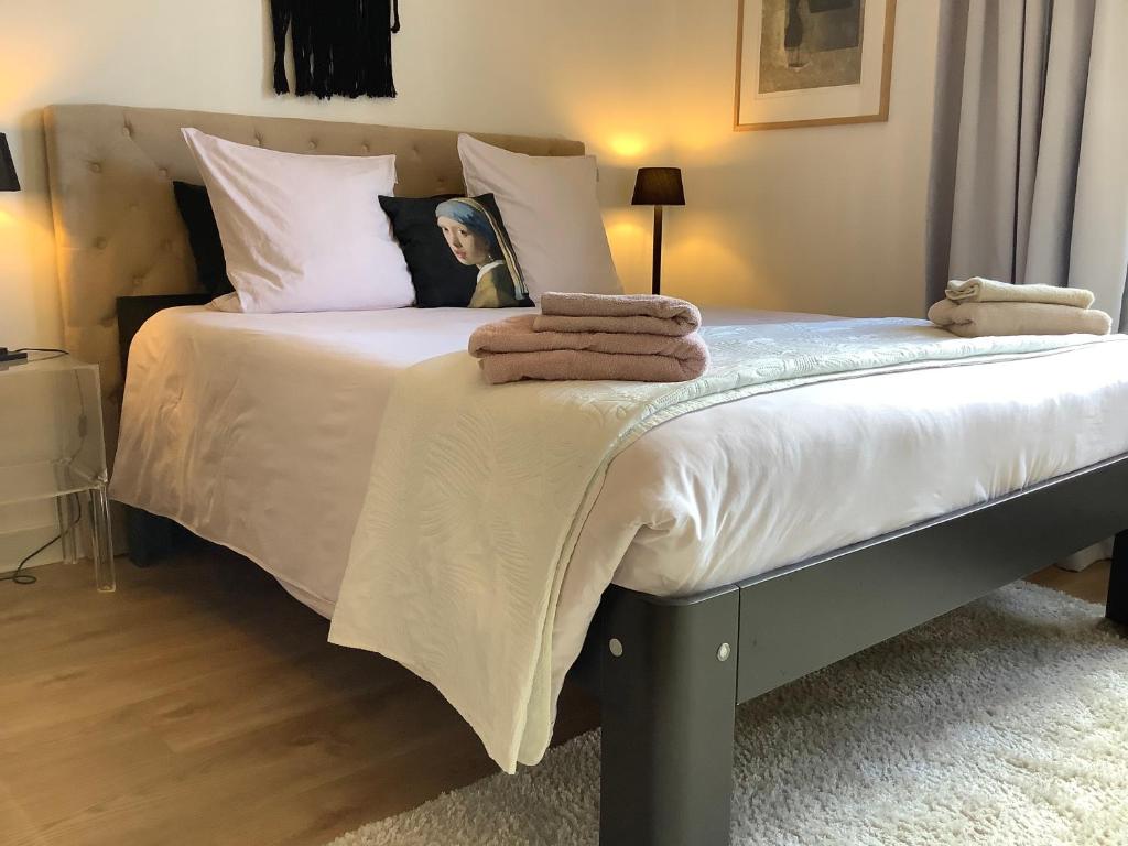 een slaapkamer met een bed met handdoeken erop bij Authentieke loft herenhuis in Oostende