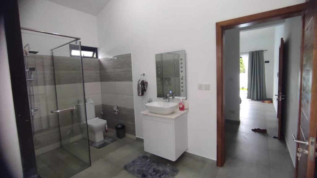 a bathroom with a sink and a shower and a toilet at Villa Sakura in Poste Lafayette