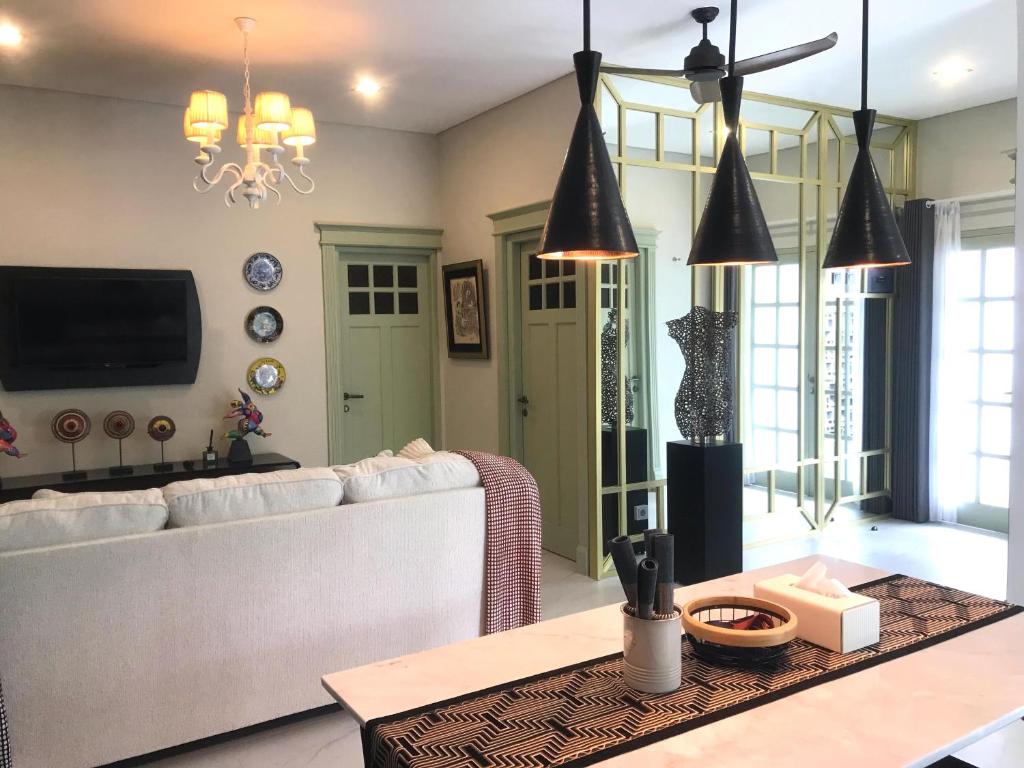 Rumah Kenyeri في دينباسار: غرفة معيشة مع أريكة بيضاء وطاولة