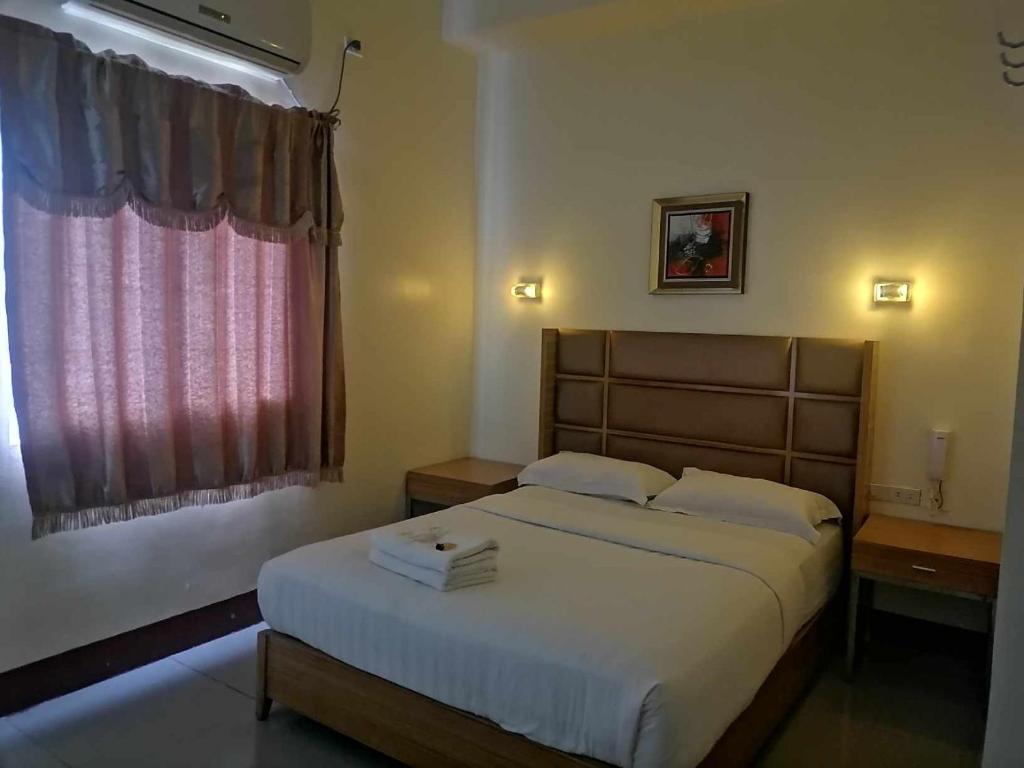 a bedroom with a large bed and a window at Asia Novo Boutique Hotel - Midsayap in Midsayap