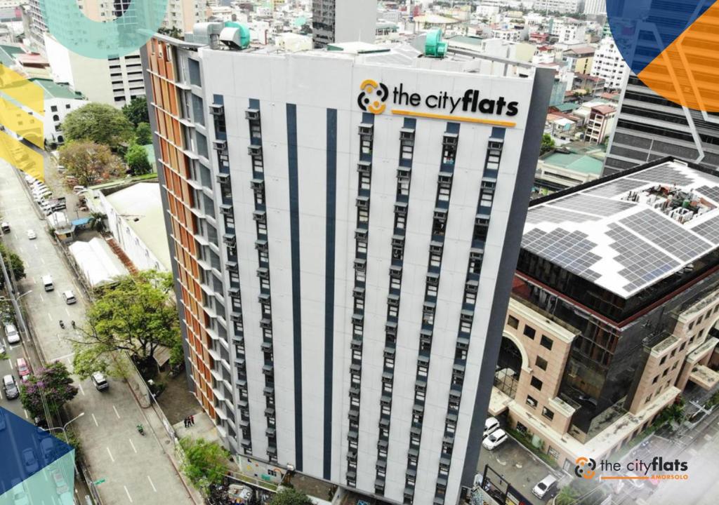 un edificio alto con el letrero de las luces de la ciudad. en The Flats Amorsolo, en Manila