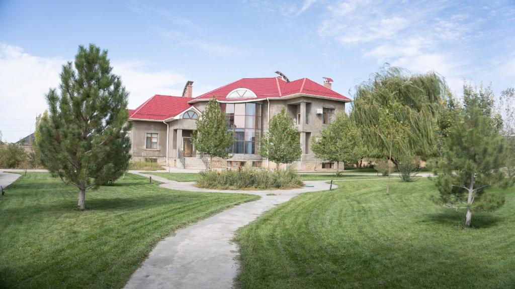 duży dom z czerwonym dachem i chodnikiem w obiekcie Saule Guest House w mieście Szymkent