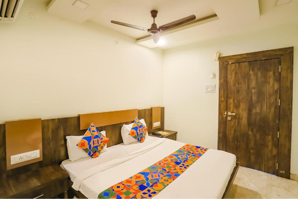 a bedroom with a bed and a ceiling fan at FabHotel Krishna in Nagpur