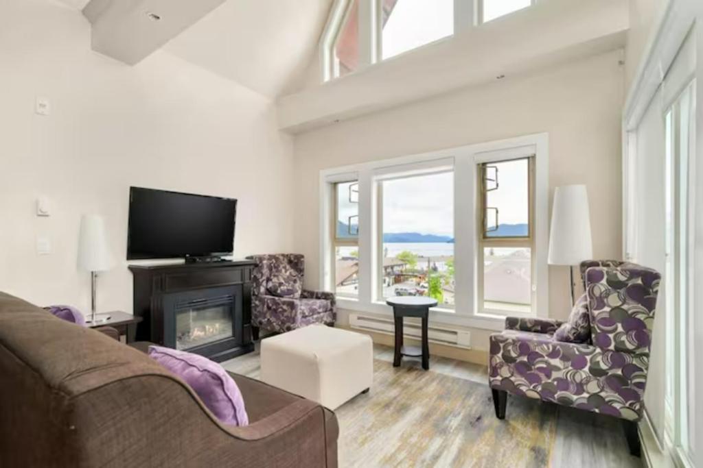 sala de estar con sofá y chimenea en Scenic 3BR Penthouse Suite w/ Rooftop Lake View, en Harrison Hot Springs