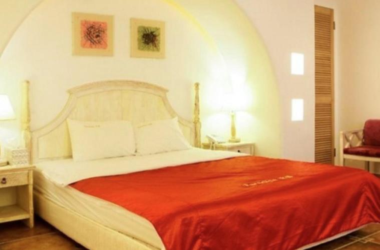 a bedroom with a large bed with a red blanket at Asan Paradise in Asan