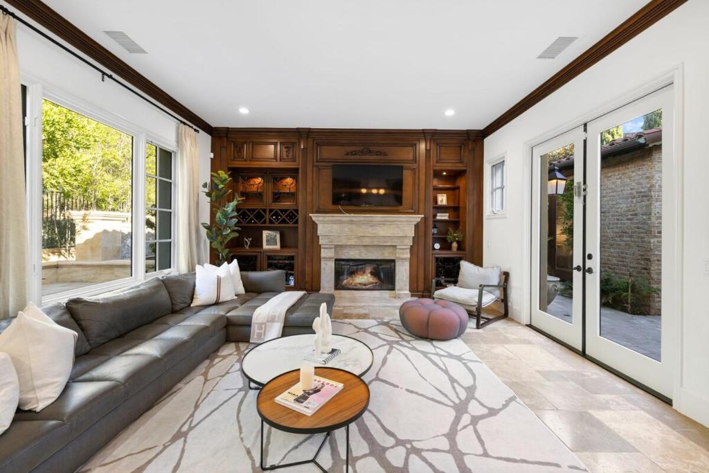 a living room with a couch and a fireplace at @ Marbella Lane - 4BR Mediterranean-style Home in Newport Beach