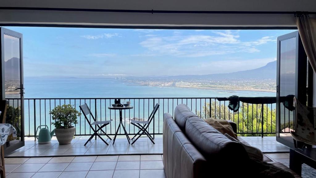 a living room with a couch and a view of the ocean at Sea-View Family Villa in Gordonʼs Bay