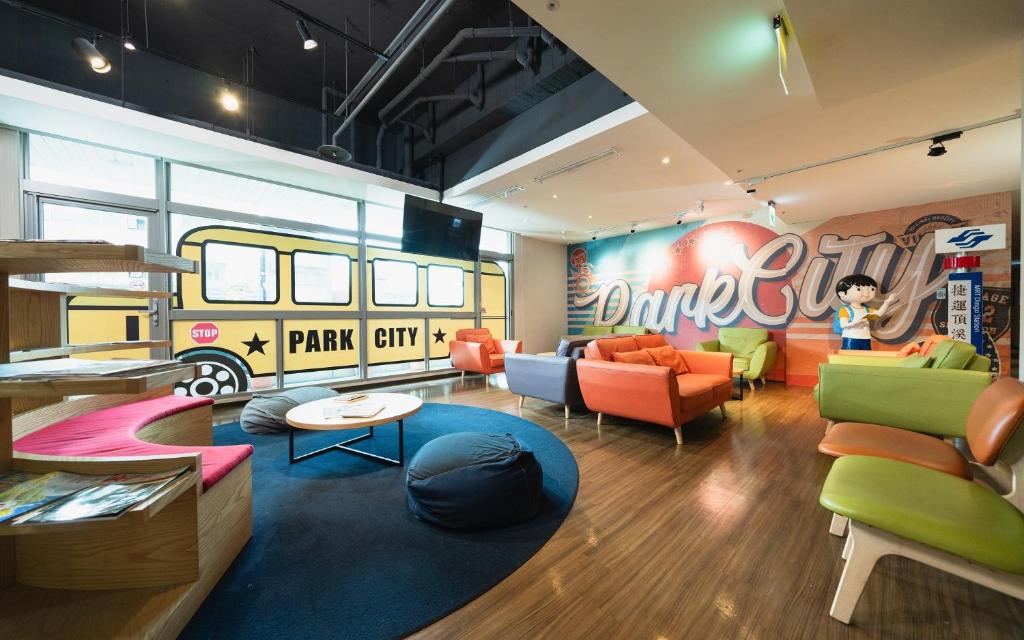 uma sala de estar com mobiliário colorido e uma área recreativa em Park City Inn & Hostel em Yonghe