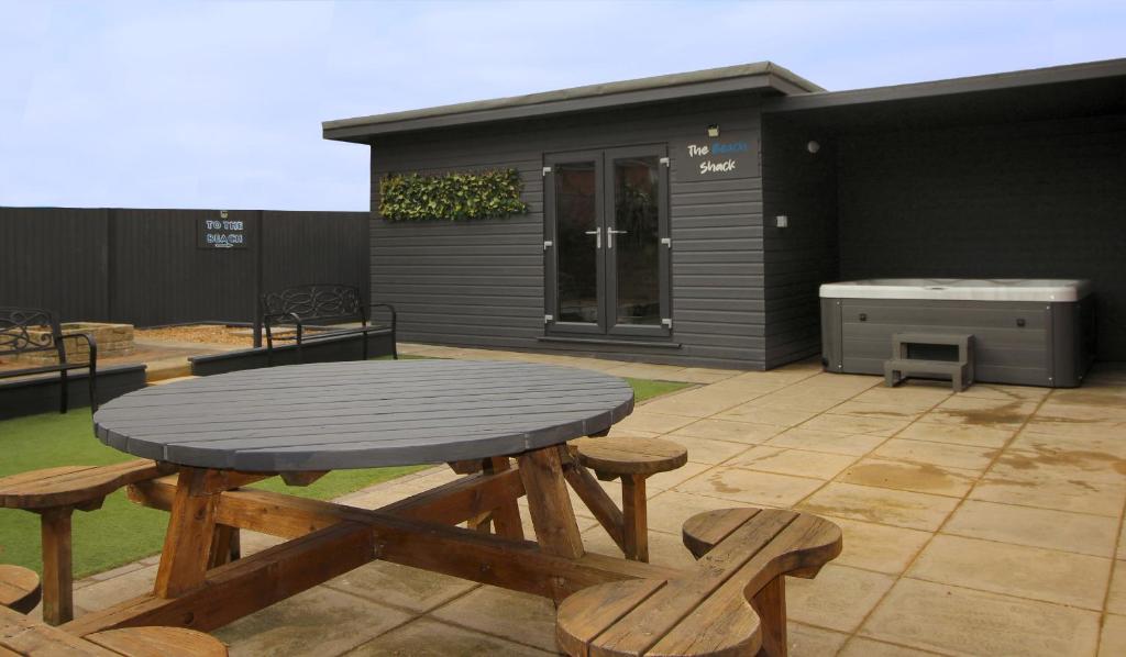 a wooden table and benches on a patio at Beachway in Prestatyn