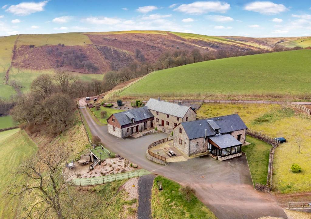 une vue aérienne sur une grande maison dans un champ dans l'établissement Beacons View Farm Cottages, à Merthyr Cynog