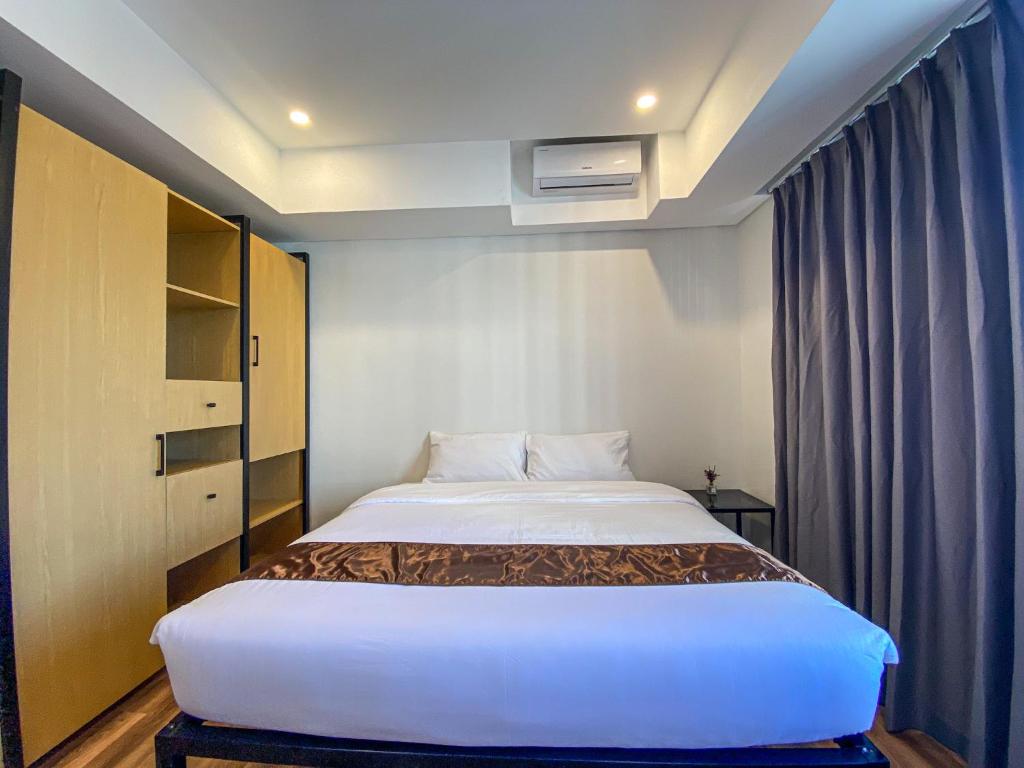 ein Schlafzimmer mit einem großen Bett in einem Zimmer in der Unterkunft Wesfame Suites in Manila