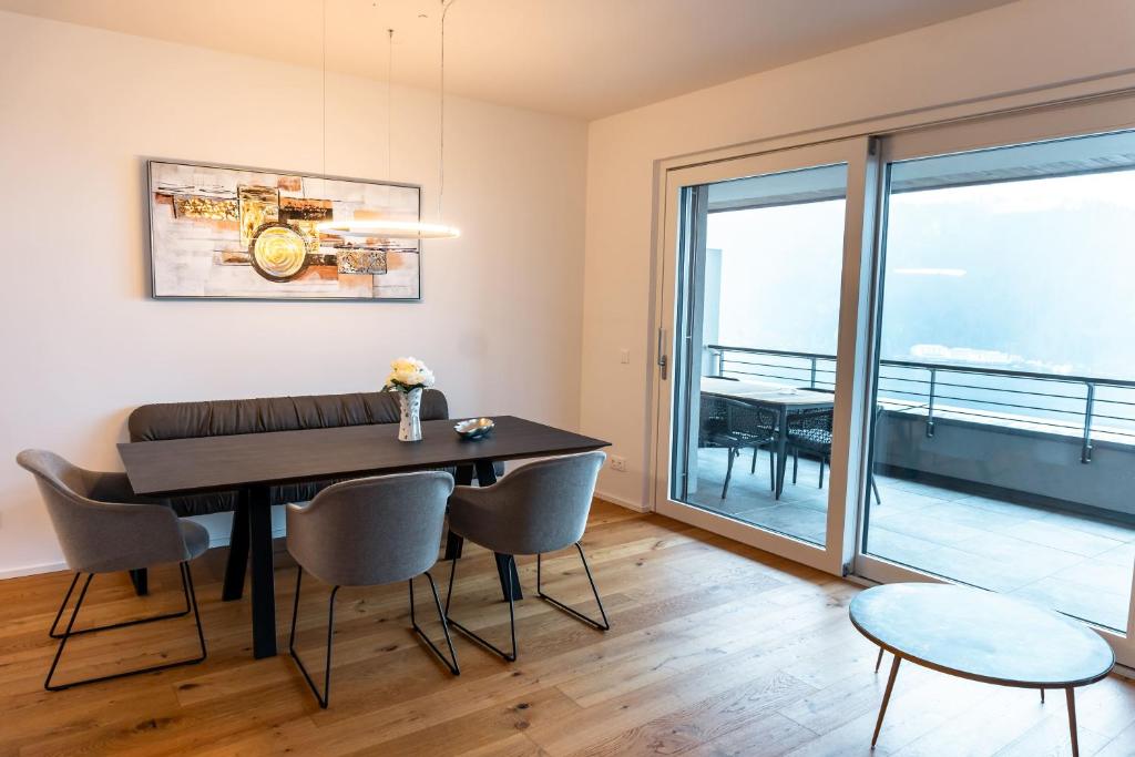 ein Esszimmer mit einem Tisch und Stühlen sowie einem Balkon in der Unterkunft Bella Vista Seeblick in Annenheim