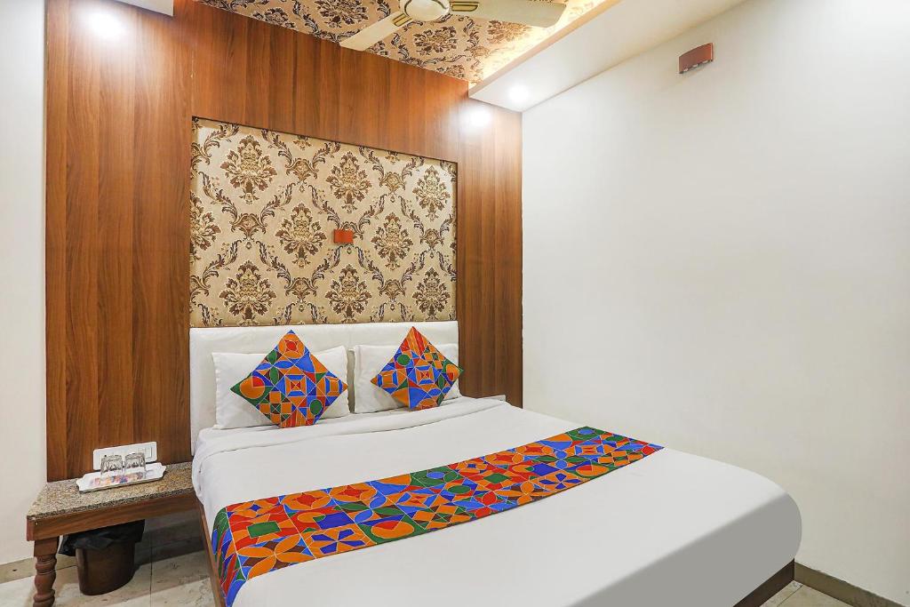 una camera con un letto bianco e una parete in legno di FabExpress Jai Manglam Service Apartment a Nagpur