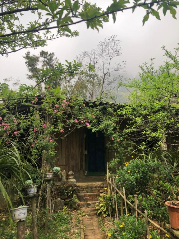 uma pequena casa com uma porta com flores em `Sin Chai Homestay em Sapa