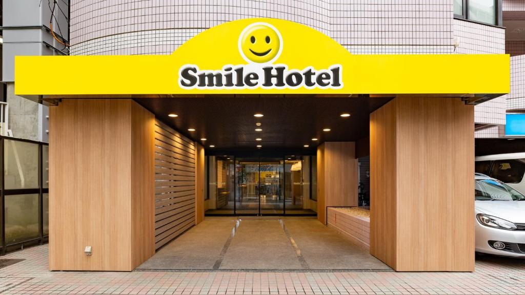 una señal de hotel sonriente en la parte delantera de un edificio en Smile Hotel Tokyo Asagaya, en Tokio