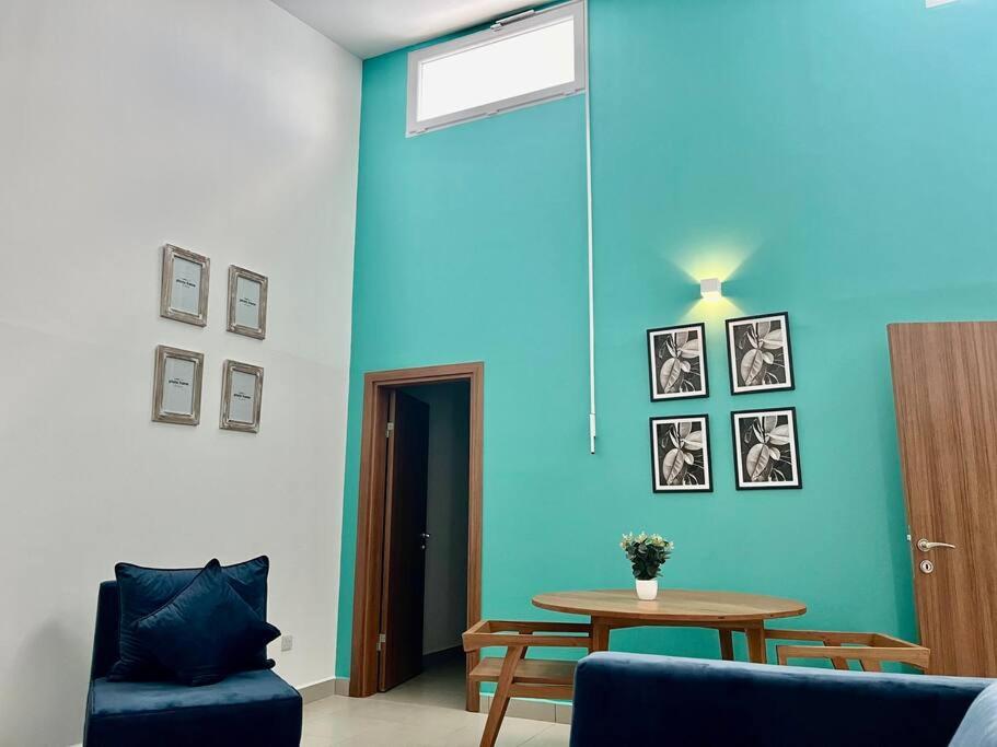 una sala de estar con una pared azul y una mesa en A Home Away from Home. en Fumba