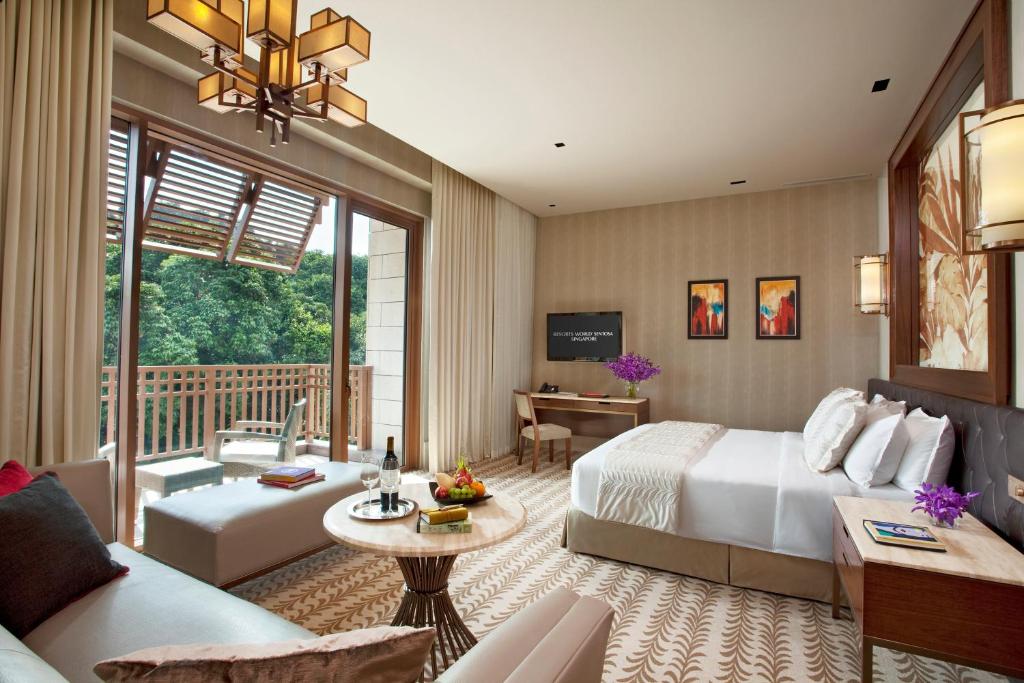 a bedroom with a bed and a living room at Resorts World Sentosa - Equarius Hotel in Singapore