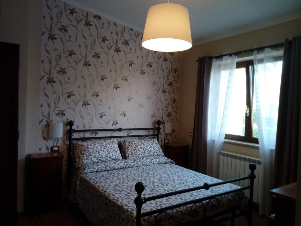 una camera da letto con un letto con carta da parati floreale di Villa Arianna a Cori