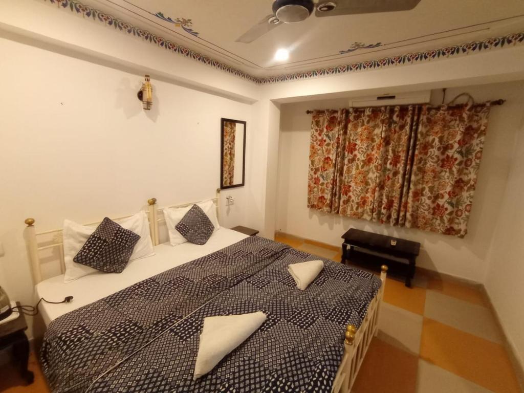 a bedroom with a bed with a black and white comforter at Little Peepal House in Udaipur