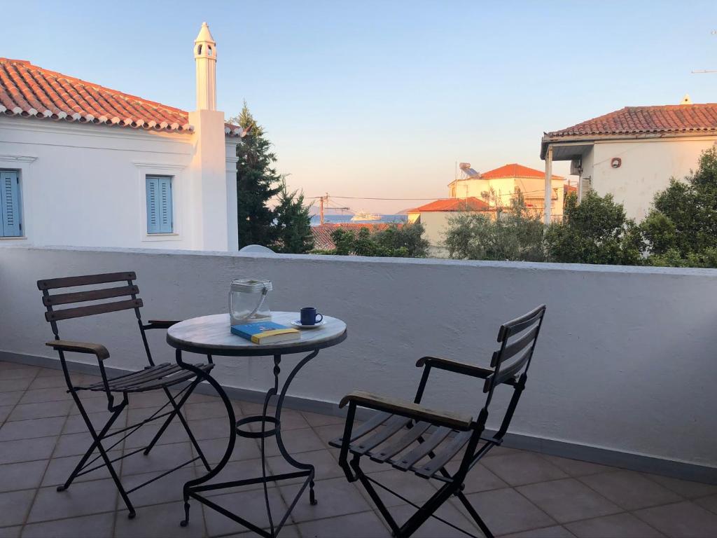 un tavolo e sedie su un balcone con vista di Summer Villa Zefiros, close to Kaiki beach a Spetses