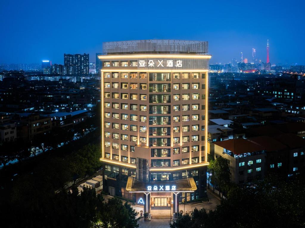 un grand bâtiment avec un panneau dessus la nuit dans l'établissement Atour X Hotel Guangzhou Avenue South Canton Fair-Free shuttle bus to Canton Fair, à Canton