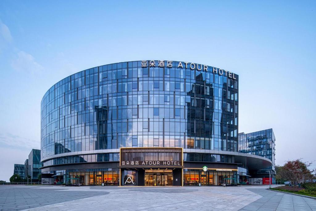 a large glass building with a sign on it at Atour Hotel Nanjing Medical Valley Xinghuo Road in Nanjing