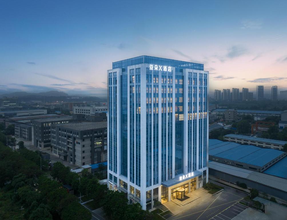un edificio alto con luci accese in una città di Atour X Hotel Nanjing Jiangning Future Internet Town a Jiangning