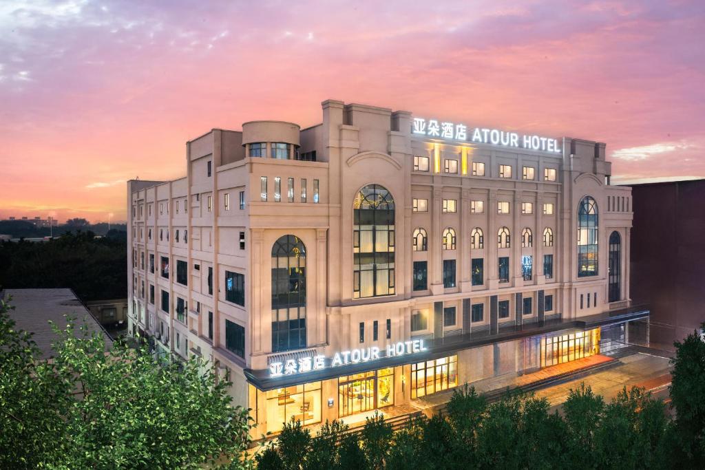 - un grand bâtiment blanc avec un panneau dans l'établissement Atour Hotel Guangzhou Baiyun Jiahe Hebian, à Canton