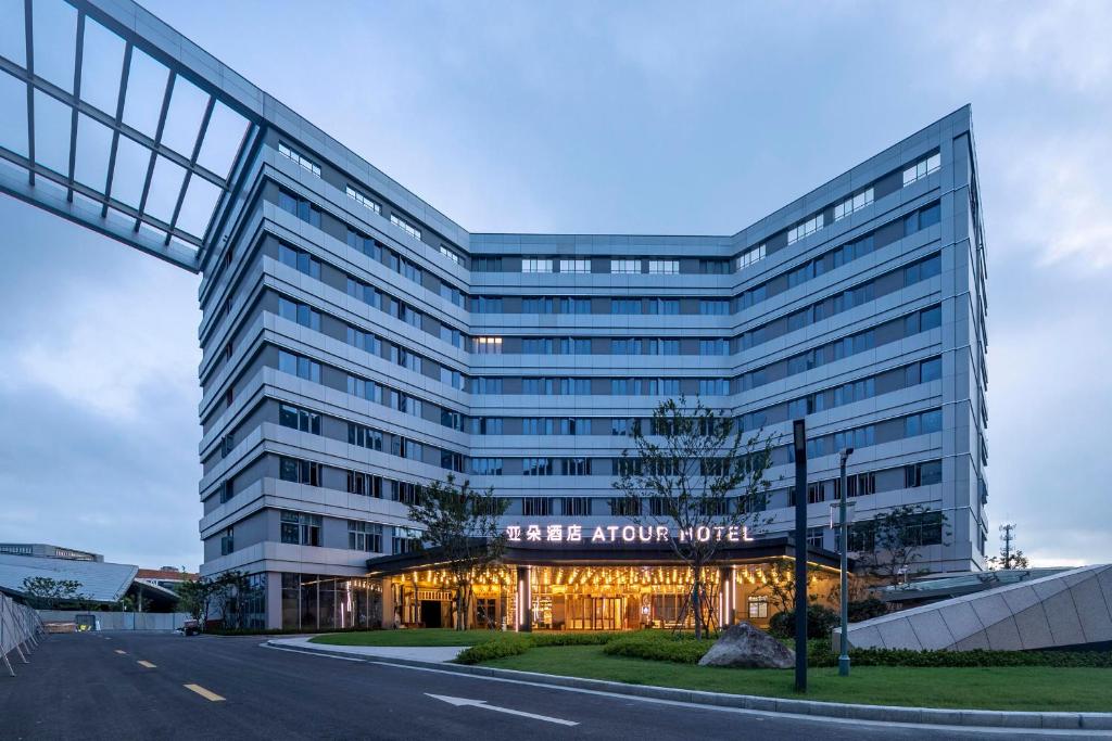 a large office building with a fire arrow hotel at Atour Hotel Ningbo Zhenhai New City in Ningbo