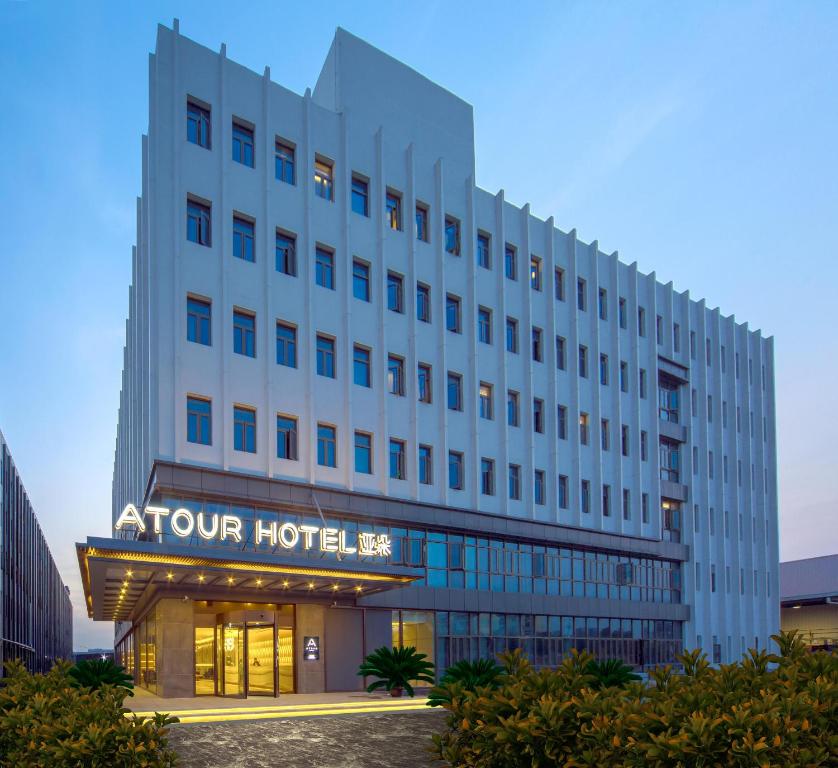 a white hotel with a sign on the front of it at Atour Hotel Shengtai West Road South Railway Station Nanjing in Nanjing