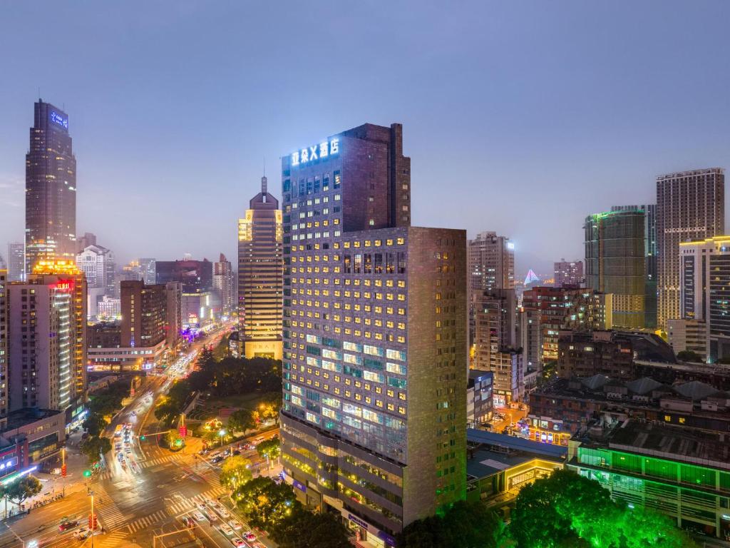 a tall building in a city at night at Atour X Hotel Wuxi Sanyang Plaza Zhongshan Road in Wuxi