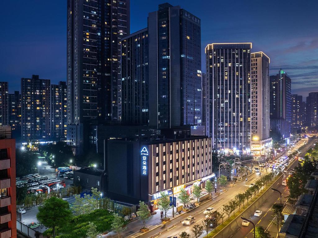 Atour Hotel Chengdu East Jiuyanqiao Street في تشنغدو: أفق المدينة في الليل مع السيارات في الشارع