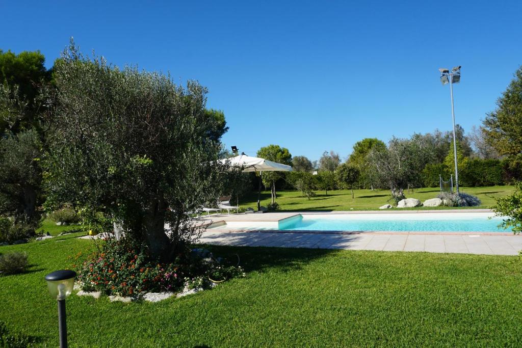 uma piscina num parque com uma árvore em Sunny House Mono with Pool - Happy Rentals em Sanarica