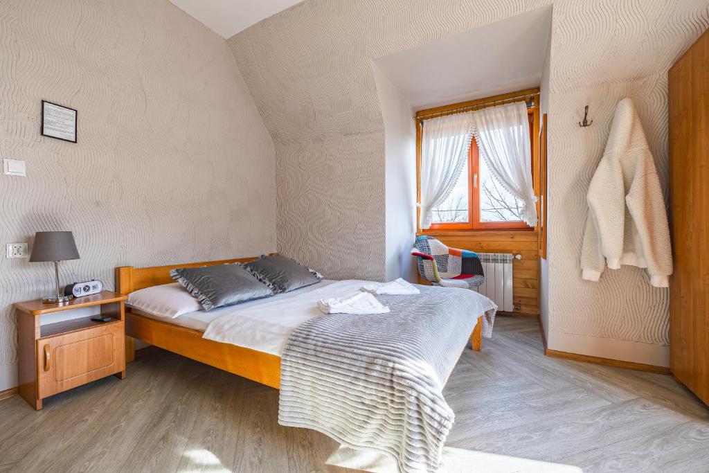 a small bedroom with a bed and a window at Pokoje gościnne Siodemka in Zakopane
